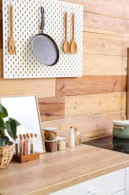 Tahta duvarda tava ve spatula asılı.