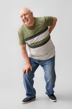 Arka planda sırt ağrısı çeken tişörtlü son sınıf öğrencisi.