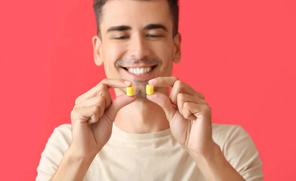 Joven Sonriente Con Tapones Amarillos Fondo Rojo Primer Plano —  Fotos de Stock