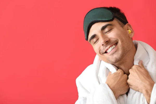 Χαμογελώντας Νεαρός Άνδρας Μάσκα Ύπνου Κουβέρτα Και Ωτοασπίδες Κόκκινο Φόντο — Φωτογραφία Αρχείου
