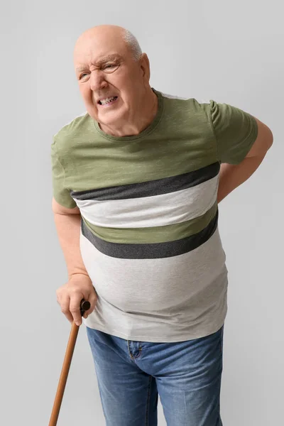 Senior Man Walking Stick Suffering Back Pain Light Background — Stockfoto