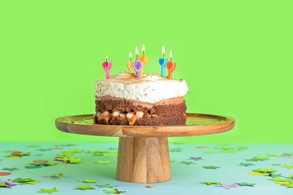 木製スタンドおいしい誕生日ケーキと緑の背景にコンフェッティ — ストック写真