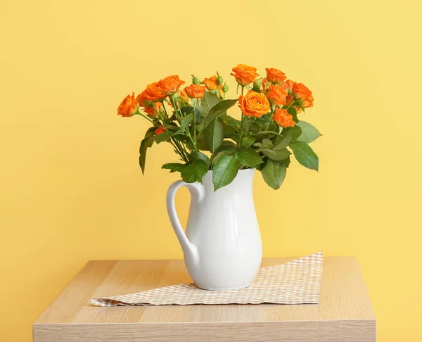 Džbán Krásnými Oranžovými Růžemi Stole Proti Žluté Zdi — Stock fotografie