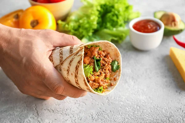 Man Holding Tasty Burrito Grey Background Closeup — Stock Photo, Image