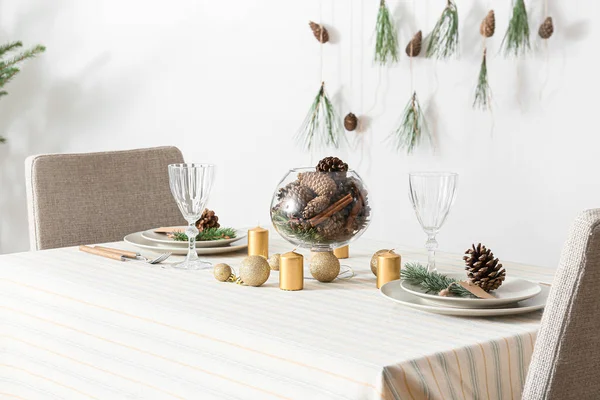 白い壁の近くに松のコーンとモミの枝と美しいテーブルの設定 — ストック写真