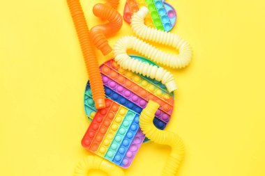 Renkli pop tüpleri ve patlayan oyuncaklar sarı arka planda