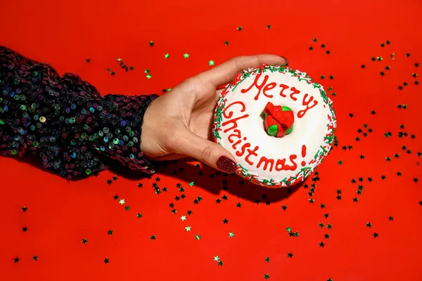 Mujer Sosteniendo Sabroso Donut Navidad Sobre Fondo Rojo — Foto de Stock