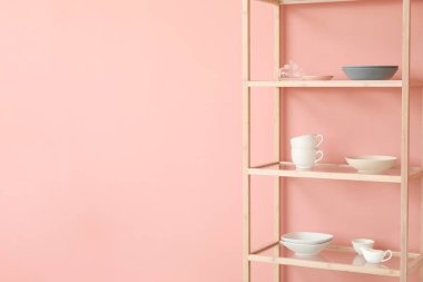 Tabakları pembe duvara yakın raflarda.