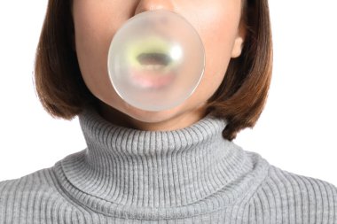 Beyaz arka planda sakızı olan genç bir kadın, yakın plan.