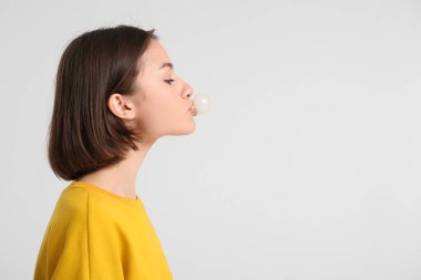 Hafif arka planda sakızı olan genç bir kadın.