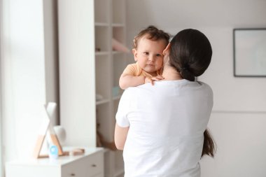 Genç anne bebeğini kucağında tutuyor.