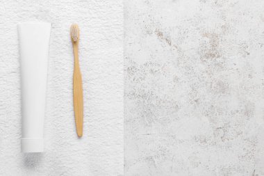 Arka planda diş macunu, fırça ve havlu bulunan tüp