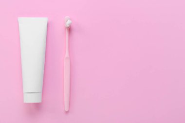 Diş macunu ve pembe arka planda fırçayla tüp