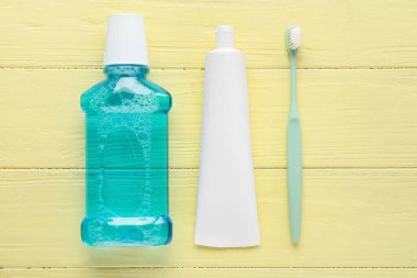 Tüp diş macunu, fırça ve gargara ile renkli ahşap arka plan