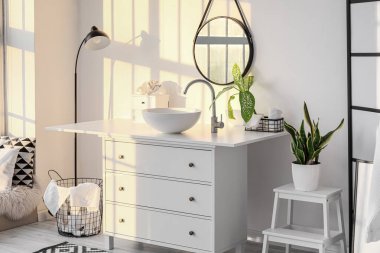 Lavabosu, aynası ve ayakta duran lambası olan hafif banyonun içi.