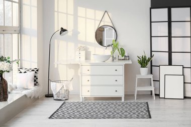 Lavabosu, aynası ve ayakta duran lambası olan hafif banyonun içi.