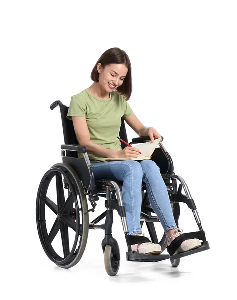 坐在轮椅上 带着白色背景笔记本的年轻女子 — 图库照片