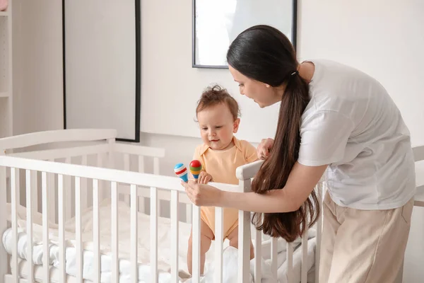 Young Mother Giving Toys Her Little Baby Crib Home — Stock Photo, Image