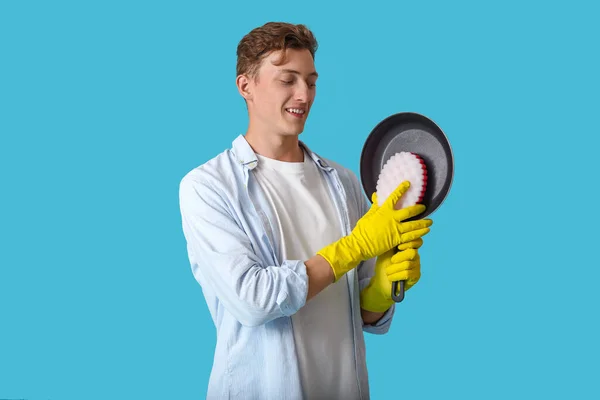 Bonito Homem Limpeza Frigideira Com Esponja Fundo Azul — Fotografia de Stock