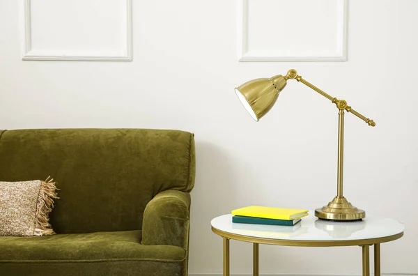 Salontafel Met Lamp Boeken Groene Bank Buurt Van Lichtmuur — Stockfoto
