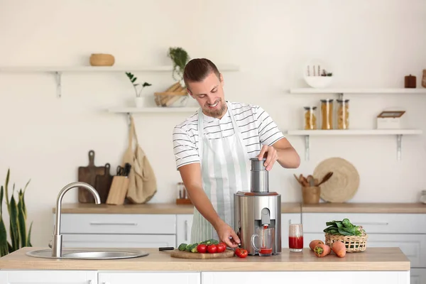 若い男は台所で健康な野菜ジュースを準備 — ストック写真