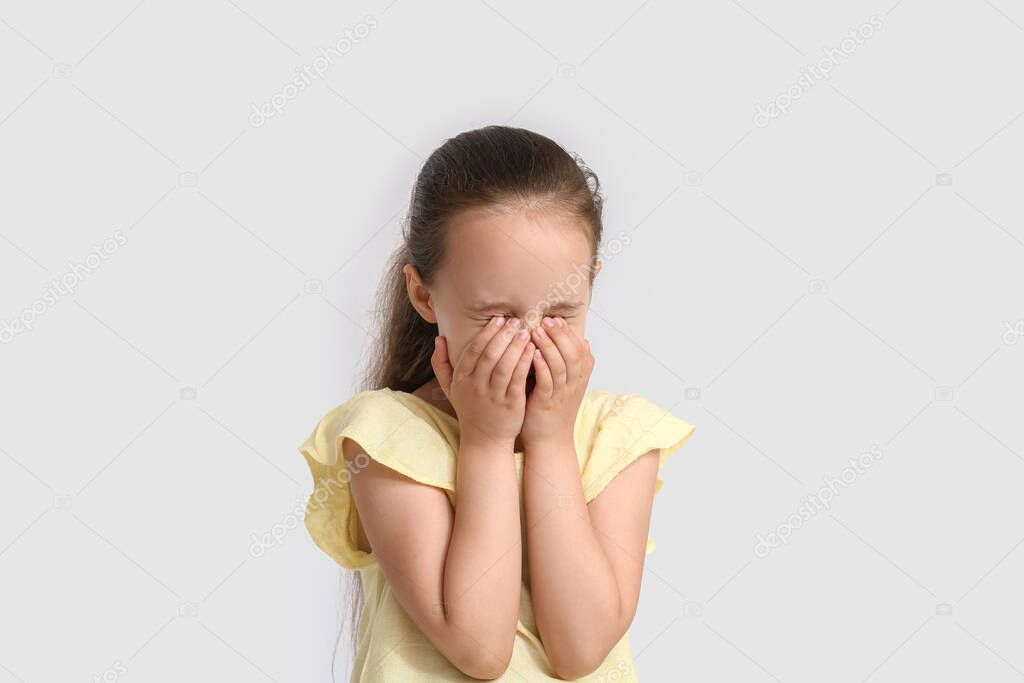 Little girl crying on white background