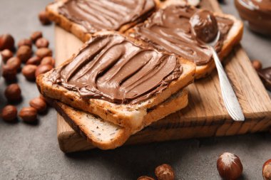 Tahta tahta tahtada çikolata ezmesi ve fındık, yakın plan.