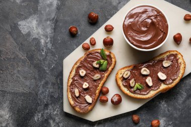 Çikolata ezmeli ekmek tahtası ve siyah fındıklı.