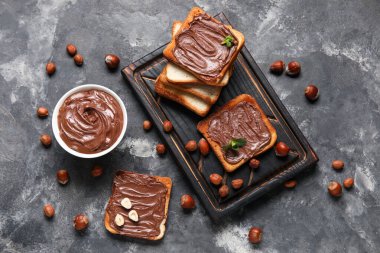 Tahta tahta tahta tahta, çikolata ezmeli ve fındıklı siyah arka plan.