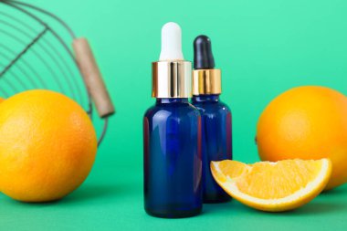 Yeşil arka planda gerekli yağ şişeleri ve taze portakallar