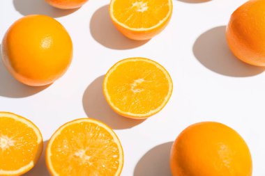 Beyaz arkaplanda taze olgun kesilmiş portakallar, yakın plan