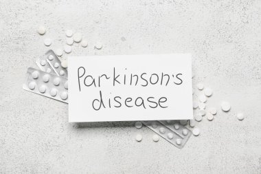 Park 'ın hastalığının yazılı olduğu kağıtlar ve grunge arkaplanda haplar.