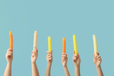 Renkli arka planda popüler pop tüpleri olan eller