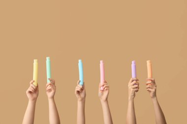 Renkli arka planda popüler pop tüpleri olan eller