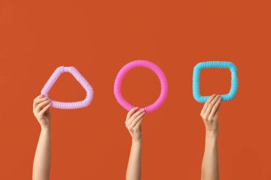 Renkli arka planda popüler pop tüpleri olan eller