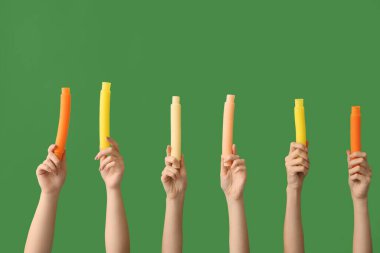 Renkli arka planda popüler pop tüpleri olan eller