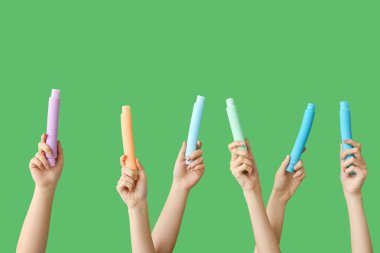 Renkli arka planda popüler pop tüpleri olan eller