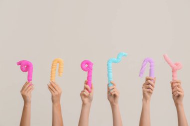 Hafif arka planda popüler pop tüpleri olan eller