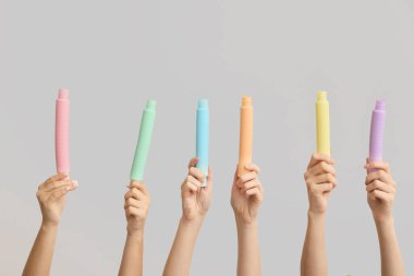 Hafif arka planda popüler pop tüpleri olan eller