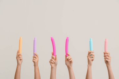 Hafif arka planda popüler pop tüpleri olan eller