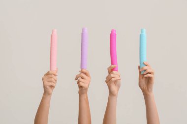 Hafif arka planda popüler pop tüpleri olan eller