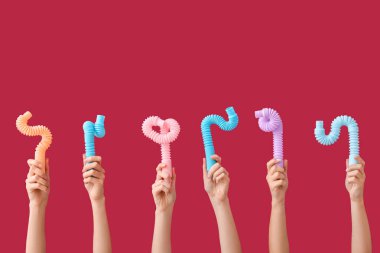 Renkli arka planda popüler pop tüpleri olan eller