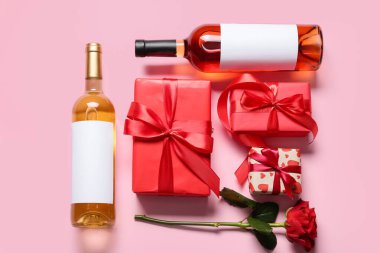 Arkaplanda hediyeler ve gül çiçekleri olan şarap şişeleri