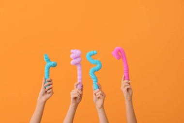 Renkli arka planda popüler pop tüpleri olan eller