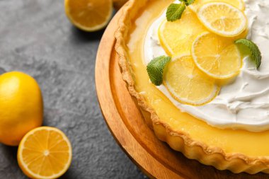 Lezzetli limonlu tartın yanında dur, koyu arkaplanda, yakın plan.