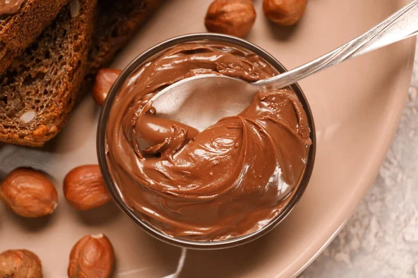 Çikolata ezmeli ve fındıklı bir tabak ekmek, yakın plan.