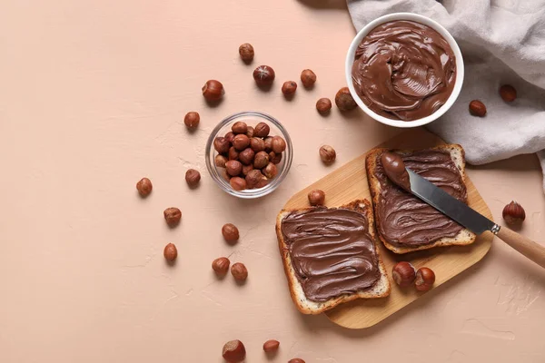 Tahta tahta tahta tahtada çikolata ezmesi ve bej arka planda fındık.