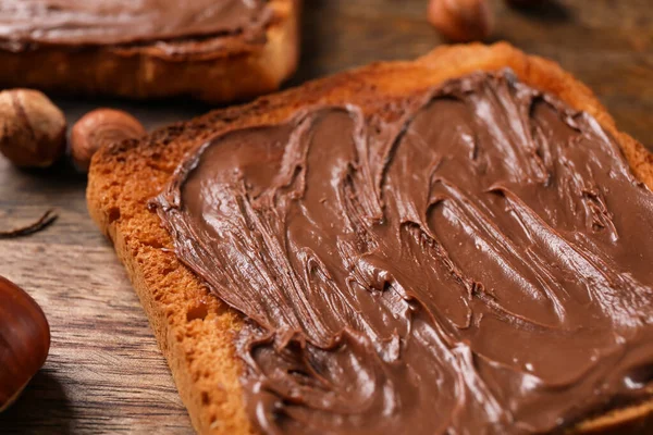 Tahta tahta tahtada çikolata ezmesi ve fındık, yakın plan.