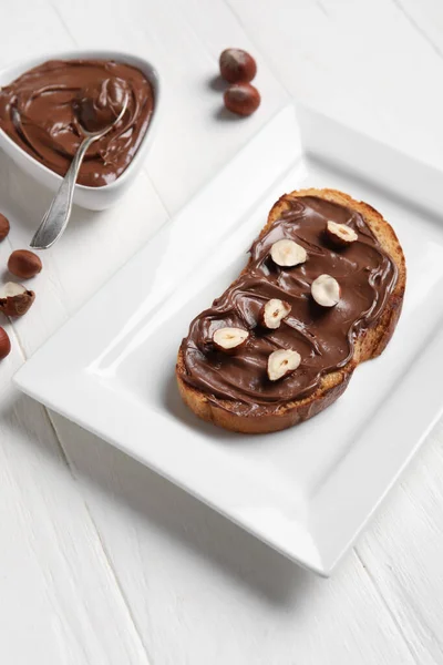 Plate Bread Chocolate Paste Hazelnuts White Wooden Background — Stock Photo, Image
