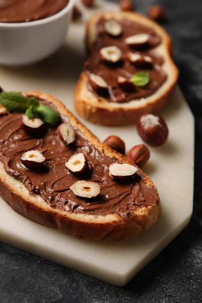 Çikolata ezmeli ve fındıklı ekmek tahtası, yakın plan.